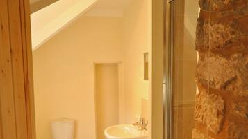 A bathroom with a toilet, sink, and shower.