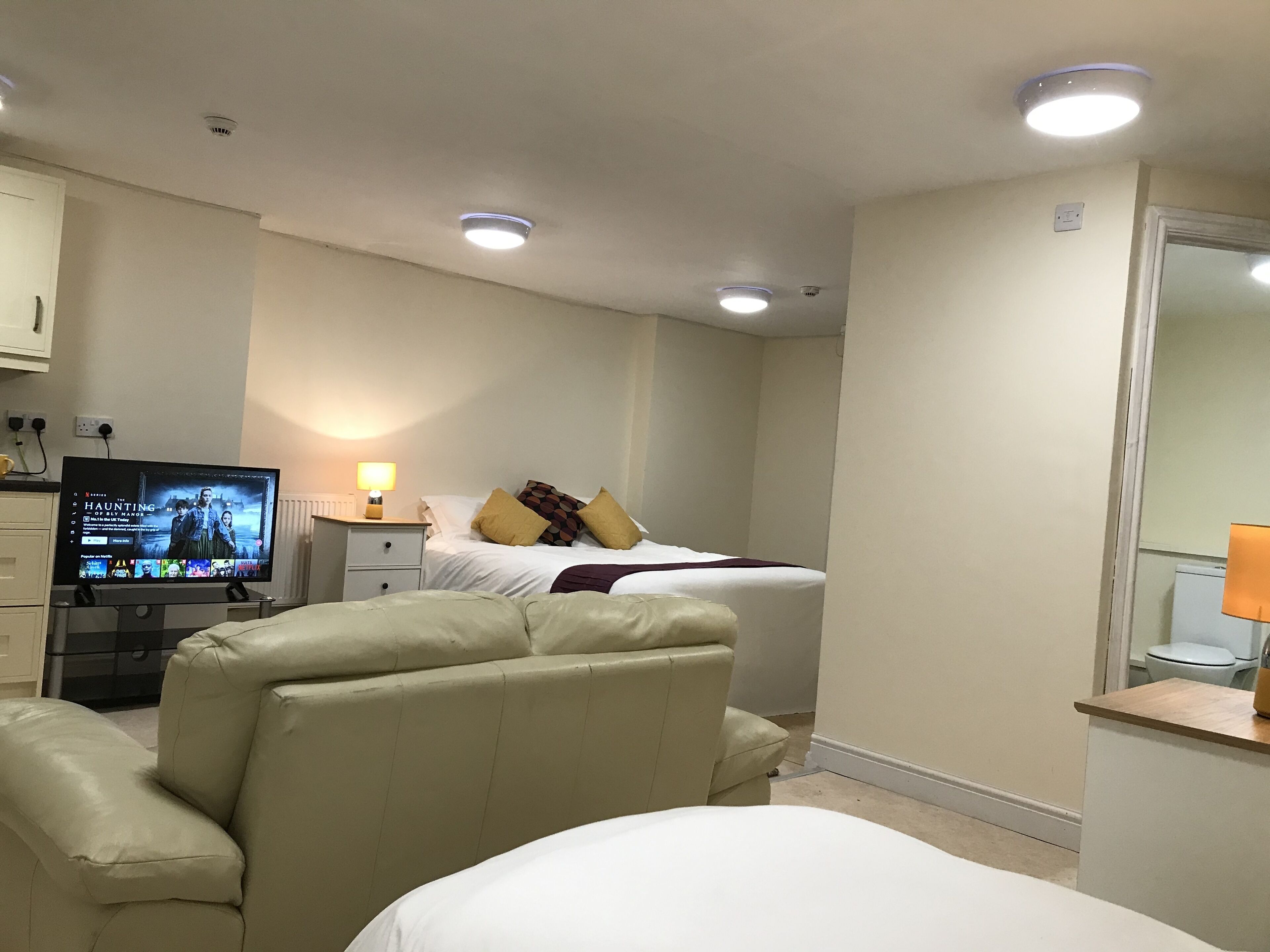 Ein Hotelzimmer mit Bett, Fernseher, Schreibtisch und Stuhl.