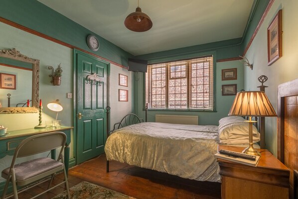 A bedroom with a bed, desk, chair, and a window with blinds. - The Golden Eagle (Chester)