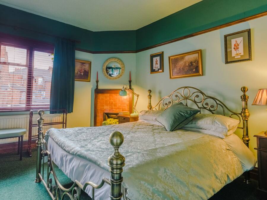 Un dormitorio tradicional con cama con dosel, un espejo y cuadros en las paredes.