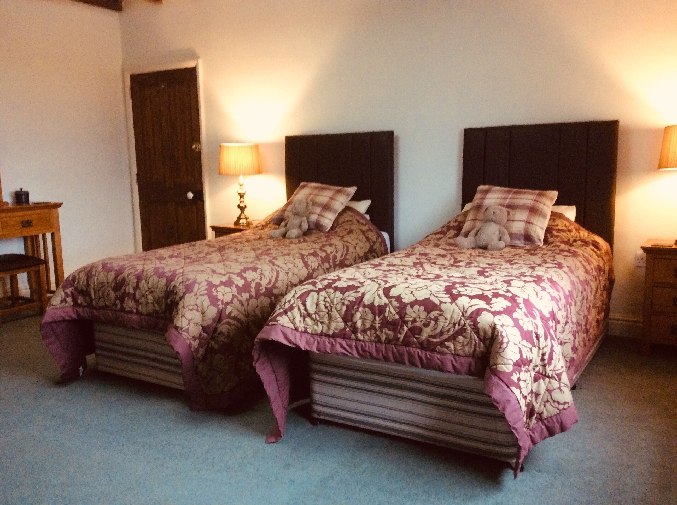 A double bed with floral bedding and two nightstands with lamps.