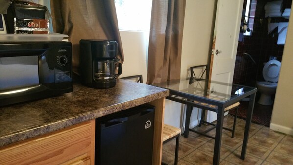 Una cocina compacta equipada con microondas, cafetera y lavavajillas.