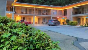 A motel with a central courtyard, multiple balconies, and a parking area. - The Happy Hollow (Hot Springs)