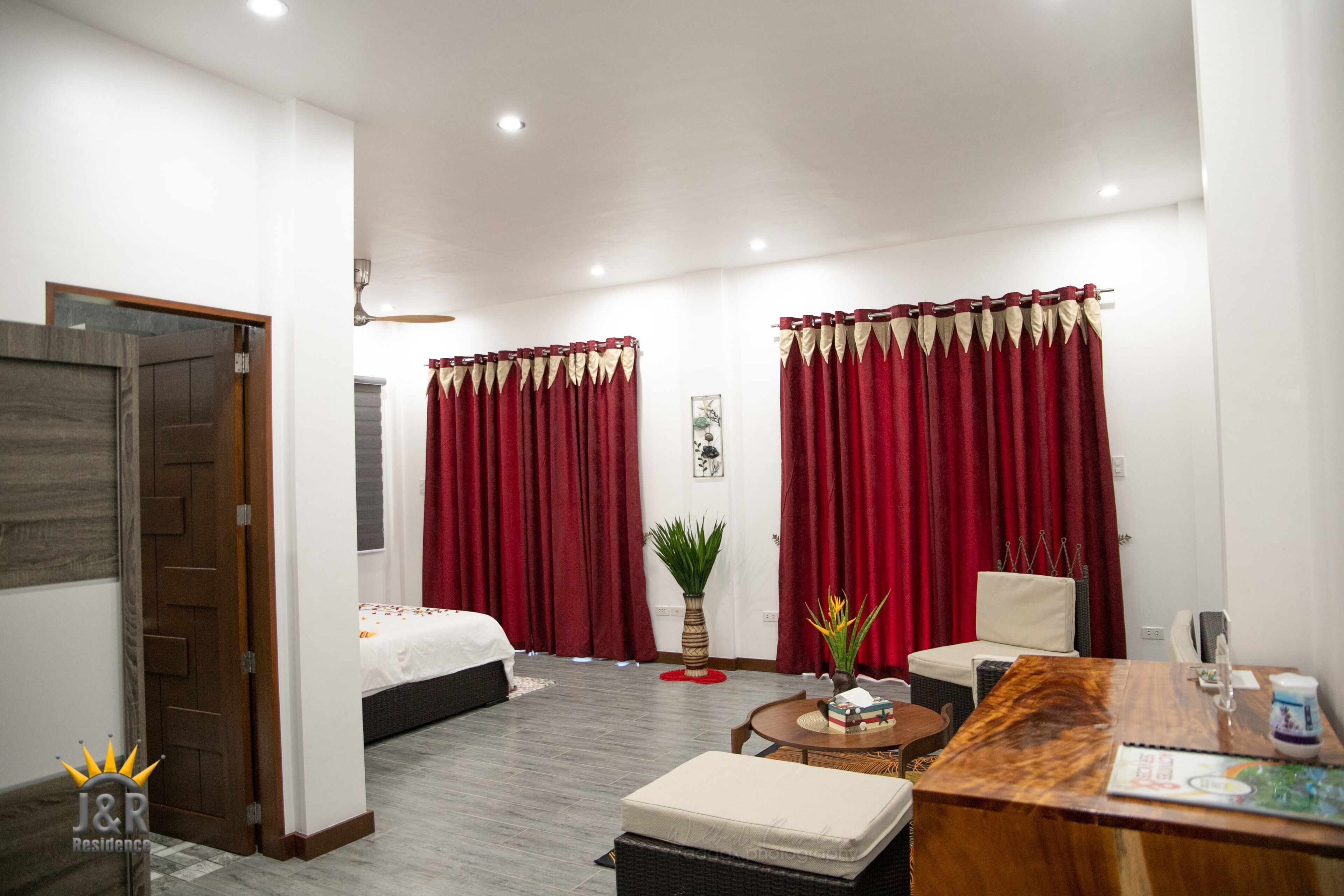 Una habitación de hotel con cama, escritorio, silla y una mesita.