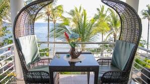 A balcony with wicker chairs, a table, and a decorative fish sculpture. - J&R Residence (Anda)
