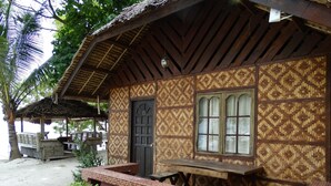 Una casa de madera tradicional con techo de paja, un ventanal grande y una puerta.
