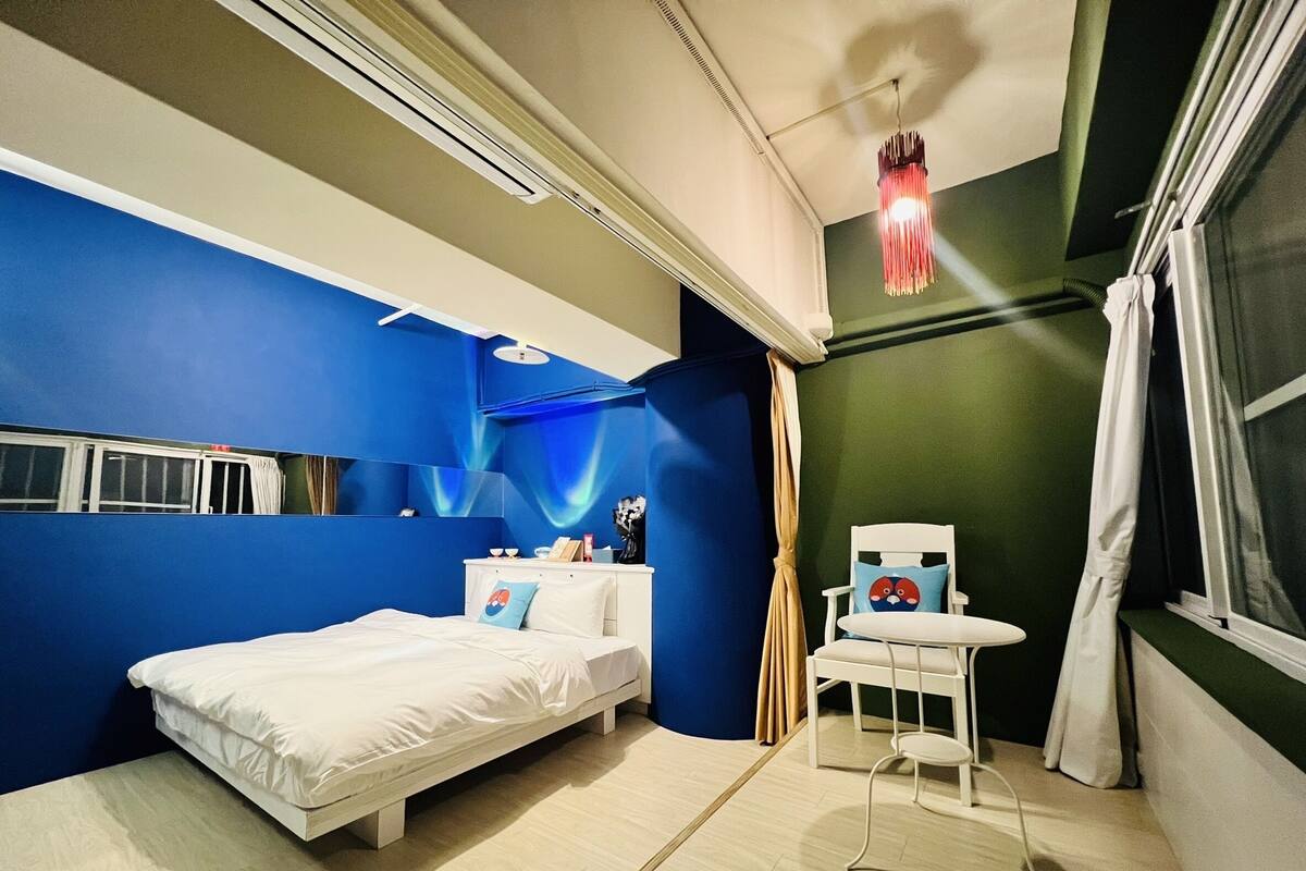 Une chambre à coucher moderne avec un lit, une petite table et une chaise.