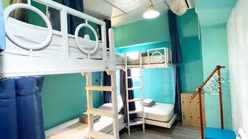 A bunk bed room with a ladder, a small table, and a chair.