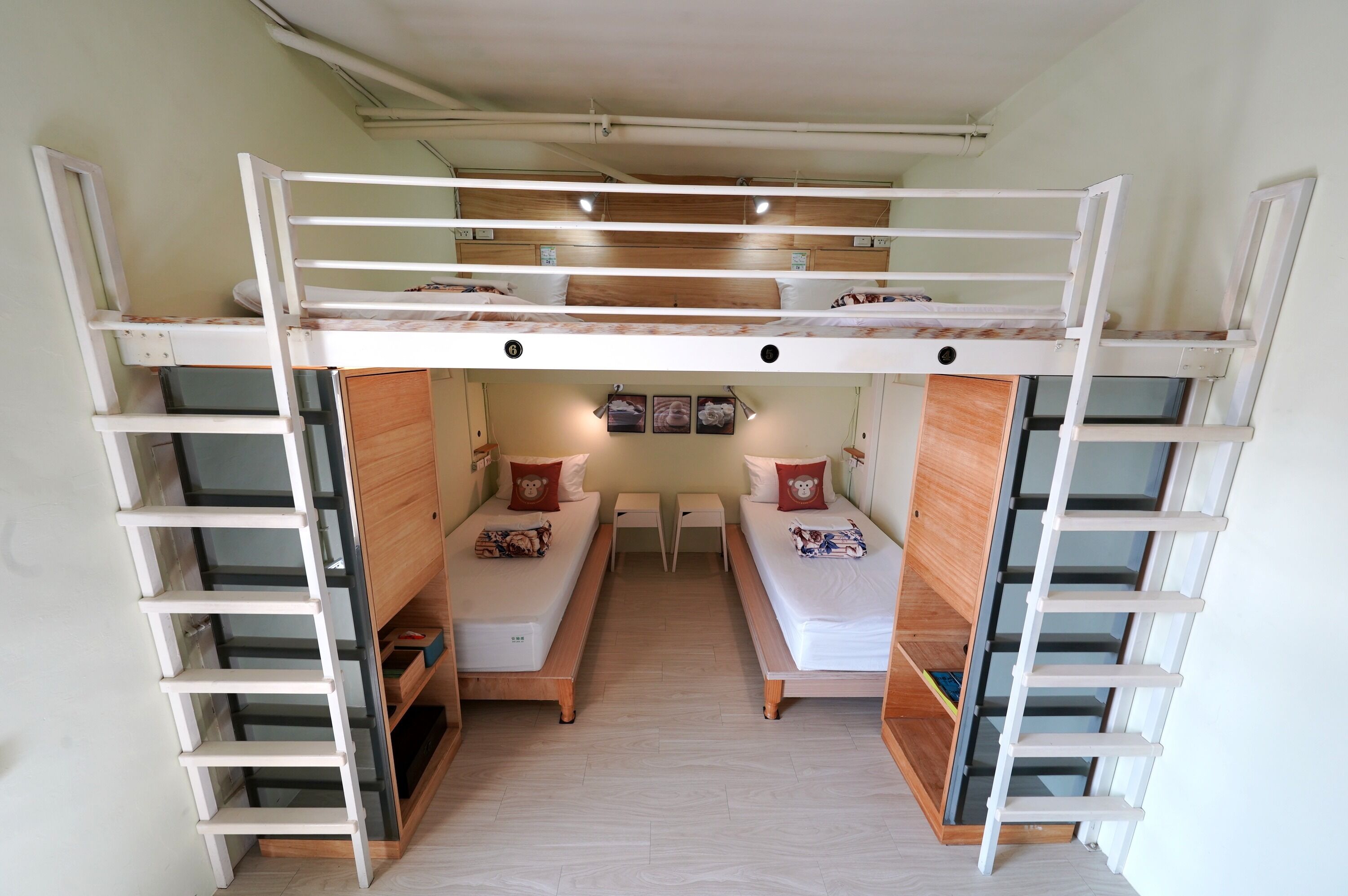 A bunk bed room with a desk and two chairs in the center.