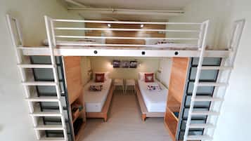 A bunk bed room with a desk and two chairs in the center.