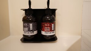 Two bottles of body wash on a black shelf. - An Lan Jie Hotel - Hostel (Chiayi City)