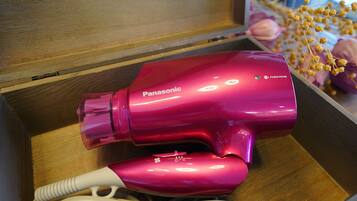 A pink Panasonic hair dryer in a wooden drawer.
