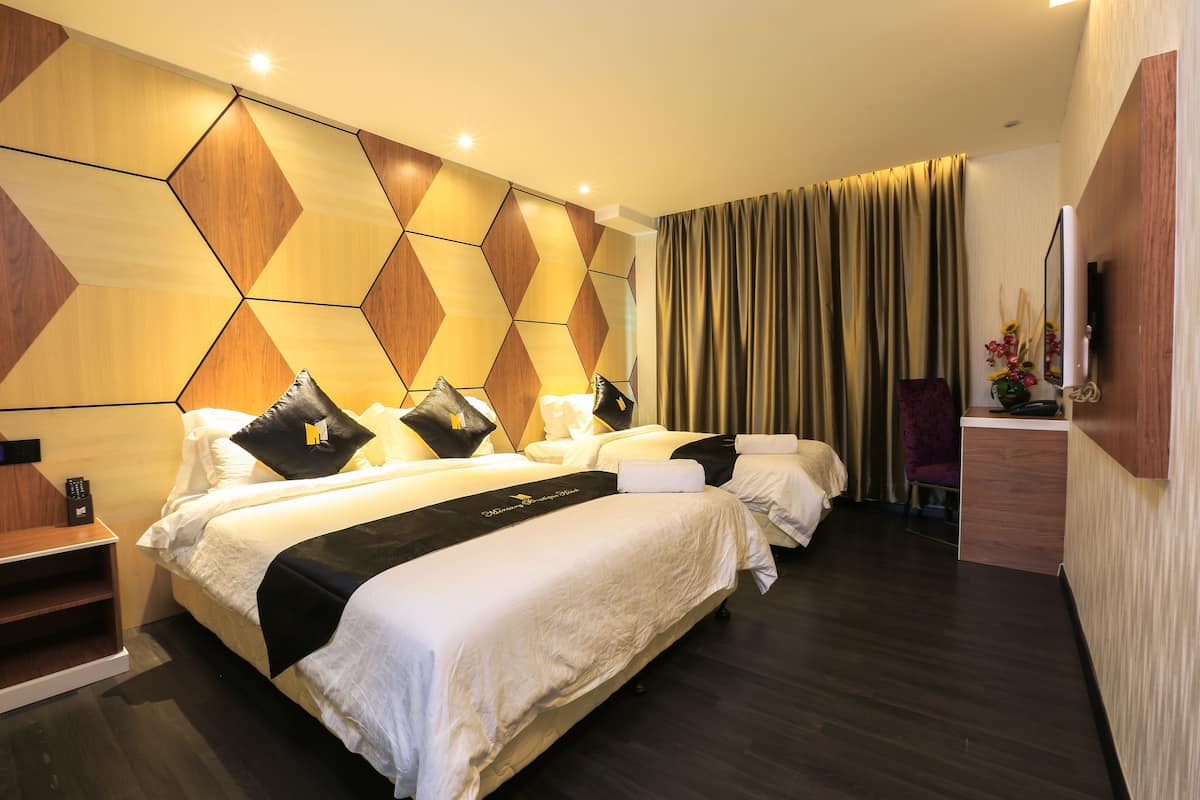 Une chambre d’hôtel avec deux lits, un bureau et un grand miroir.