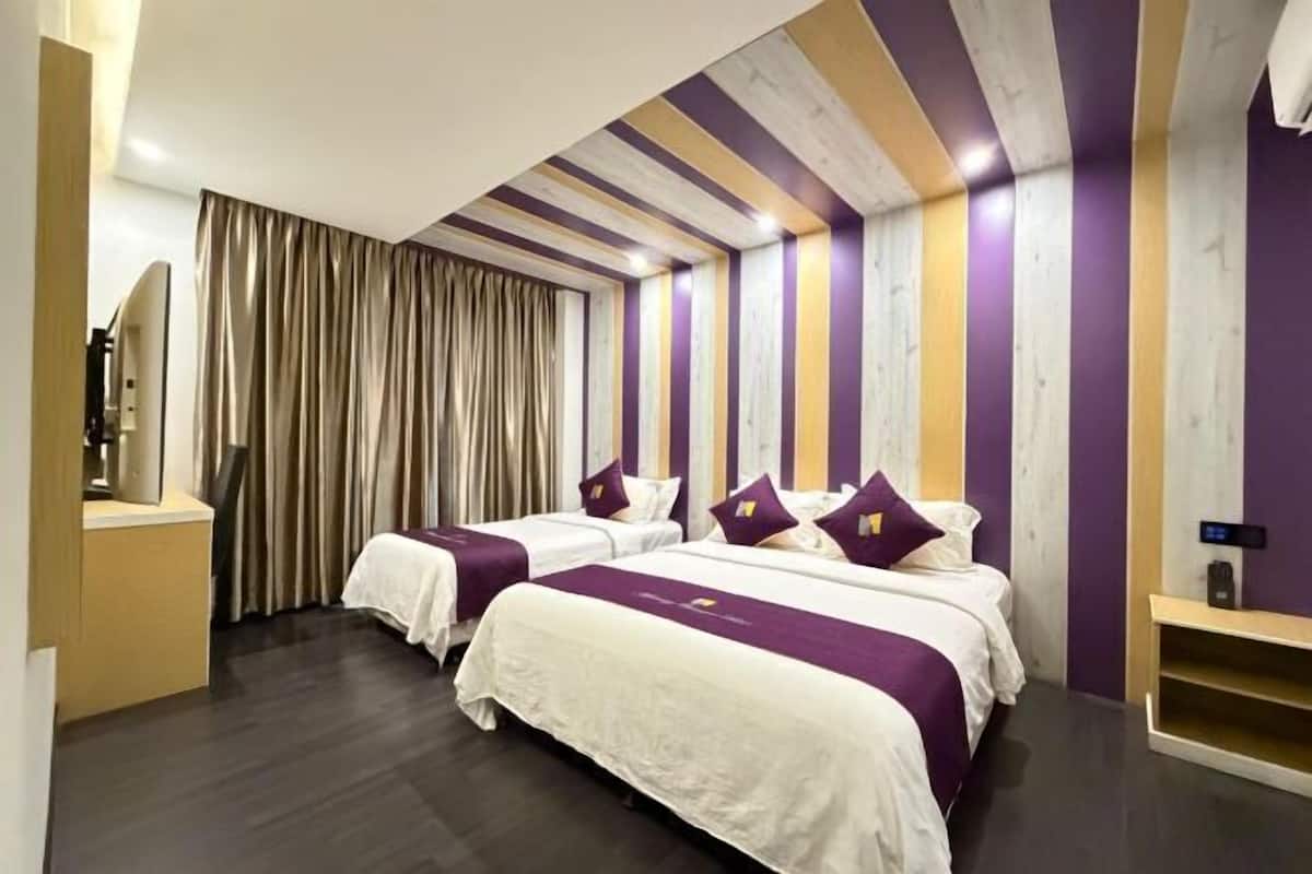 Une chambre d’hôtel avec deux lits, un plafond en bois et un rideau.