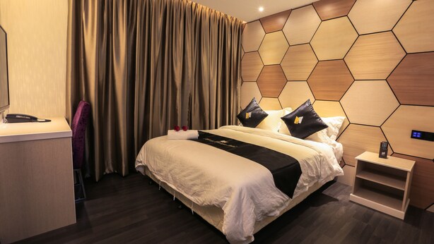 A modern hotel room with a large bed, a desk, and a control panel on the wall. - Mercury Boutique Hotel (Malacca City)
