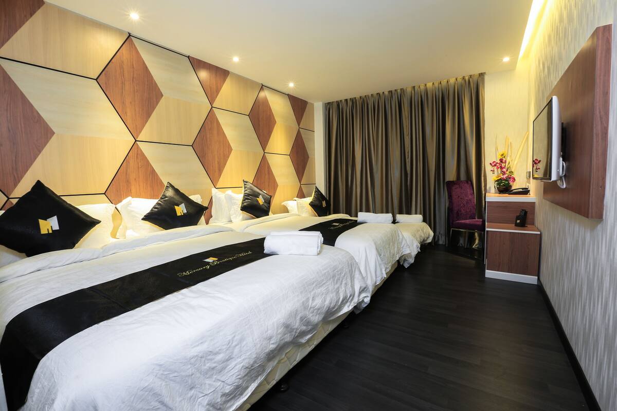 Une chambre d’hôtel avec deux lits, une télévision, un bureau et une chaise.