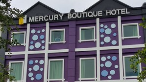 A multi-story building with a purple facade and white window frames. The name "Mercury Boutique Hotel" is displayed prominently at the top and along the ground floor. - Mercury Boutique Hotel (Malacca City)