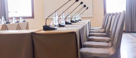 A conference room with a long table, multiple microphones, and chairs.