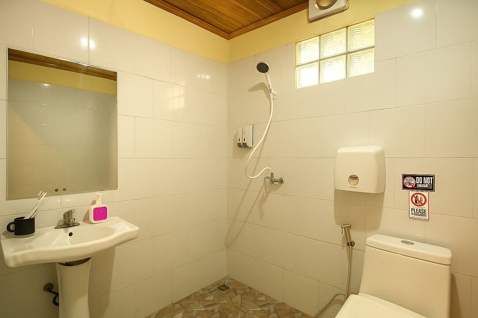 A small bathroom with a sink, mirror, toilet, and shower.