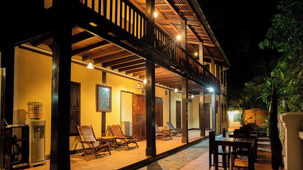 A well-lit outdoor area with wooden furniture and a covered seating area. - Villa Khoum Xieng Thong Boutique (Luang Prabang)