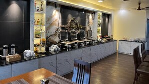 Una barra de desayuno moderna con detalles de mármol, una estación de café y zona de estar.