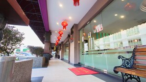 A hotel corridor with red lanterns, a wooden bench, and a red carpet. - Lavender Inn Nusa Bestari (Johor Bahru)