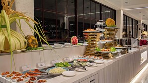 Un bufé con diferentes opciones de comida y una planta decorativa.