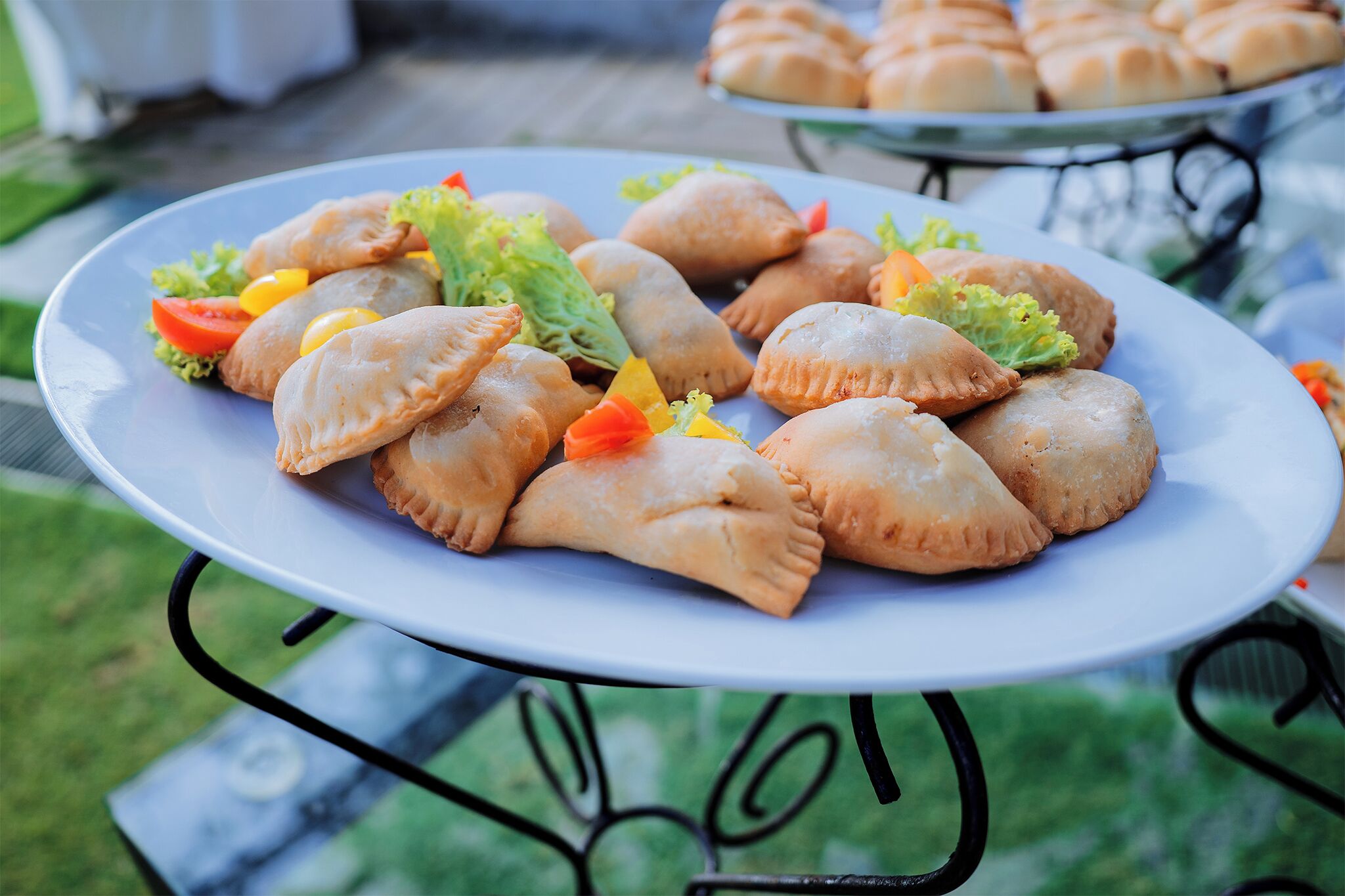 A plate of pastries on an outdoor table.