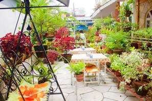 Un patio jardín con plantas en macetas, una mesa y sillas.