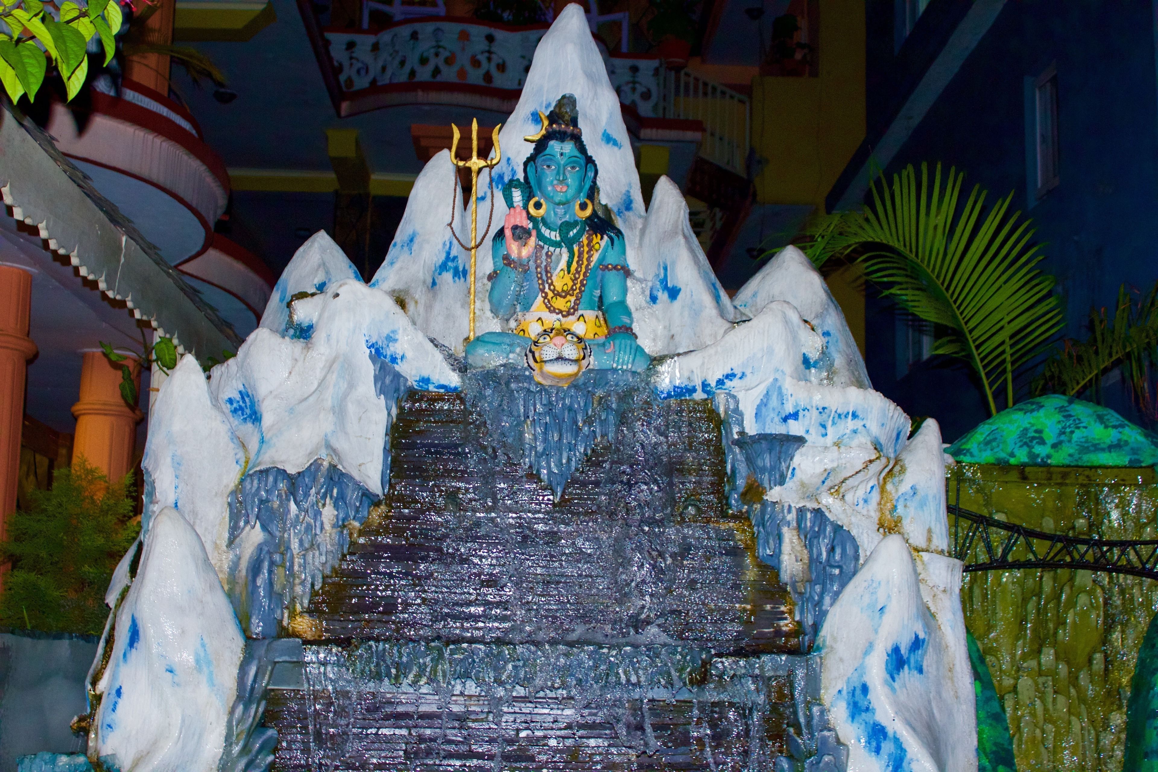 Une statue d’une divinité, placée sur un socle en pierre accessible par des marches, et entourée de structures ressemblant à de la glace.