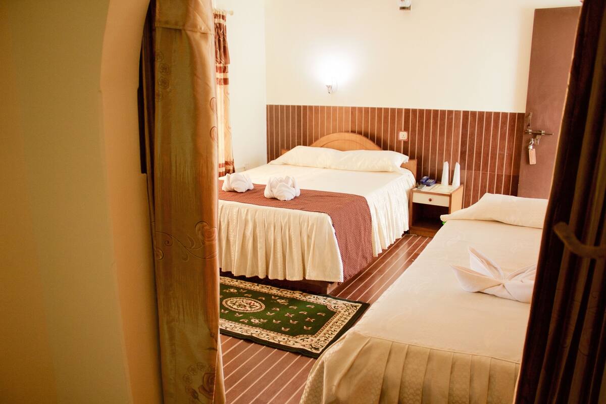 Une chambre d’hôtel avec un lit, une table de chevet et une petite table d’appoint.