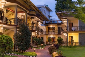 A multi-story hotel with outdoor seating areas, a well-maintained garden, and a stone facade. - Moonlight Resort and Spa (Pokhara)