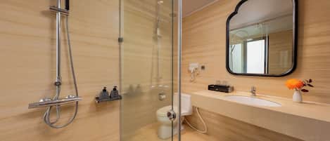 A modern bathroom with a glass-enclosed shower, a vanity with a sink, and a mirror.
