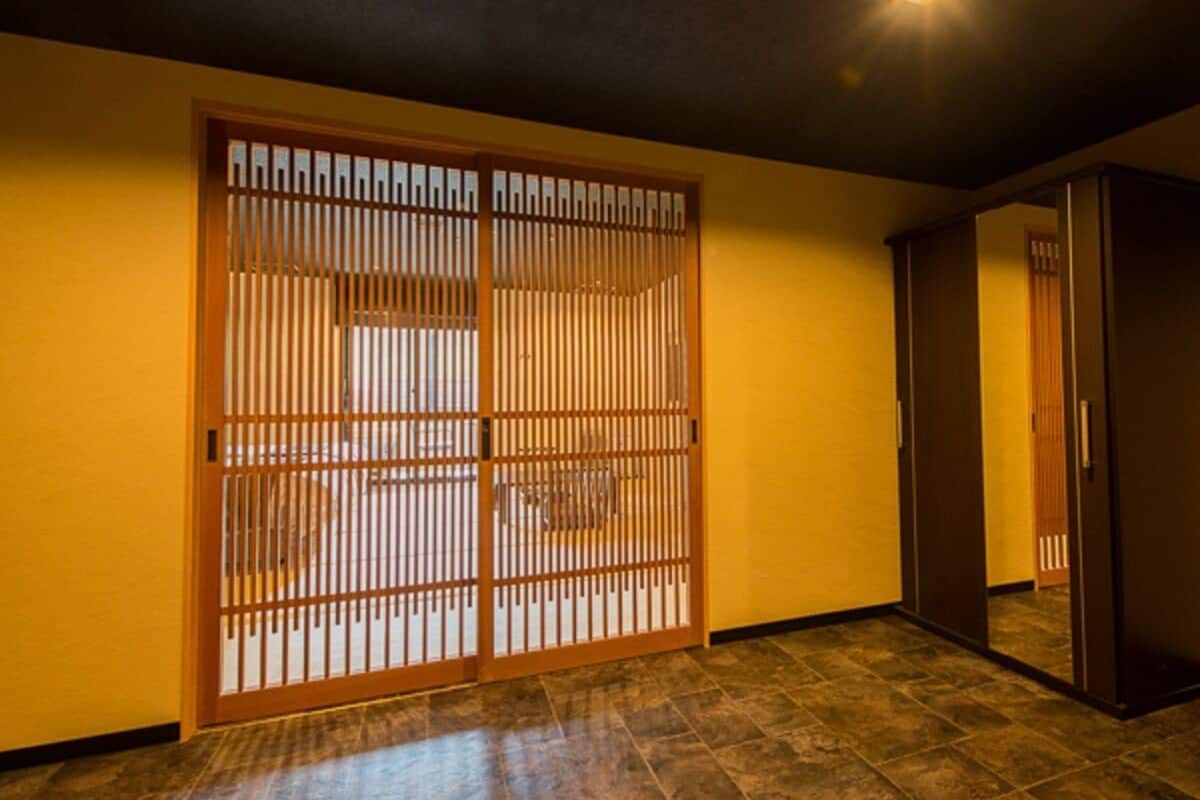 A room with a sliding shoji screen door, a dark ceiling, and a tiled floor.