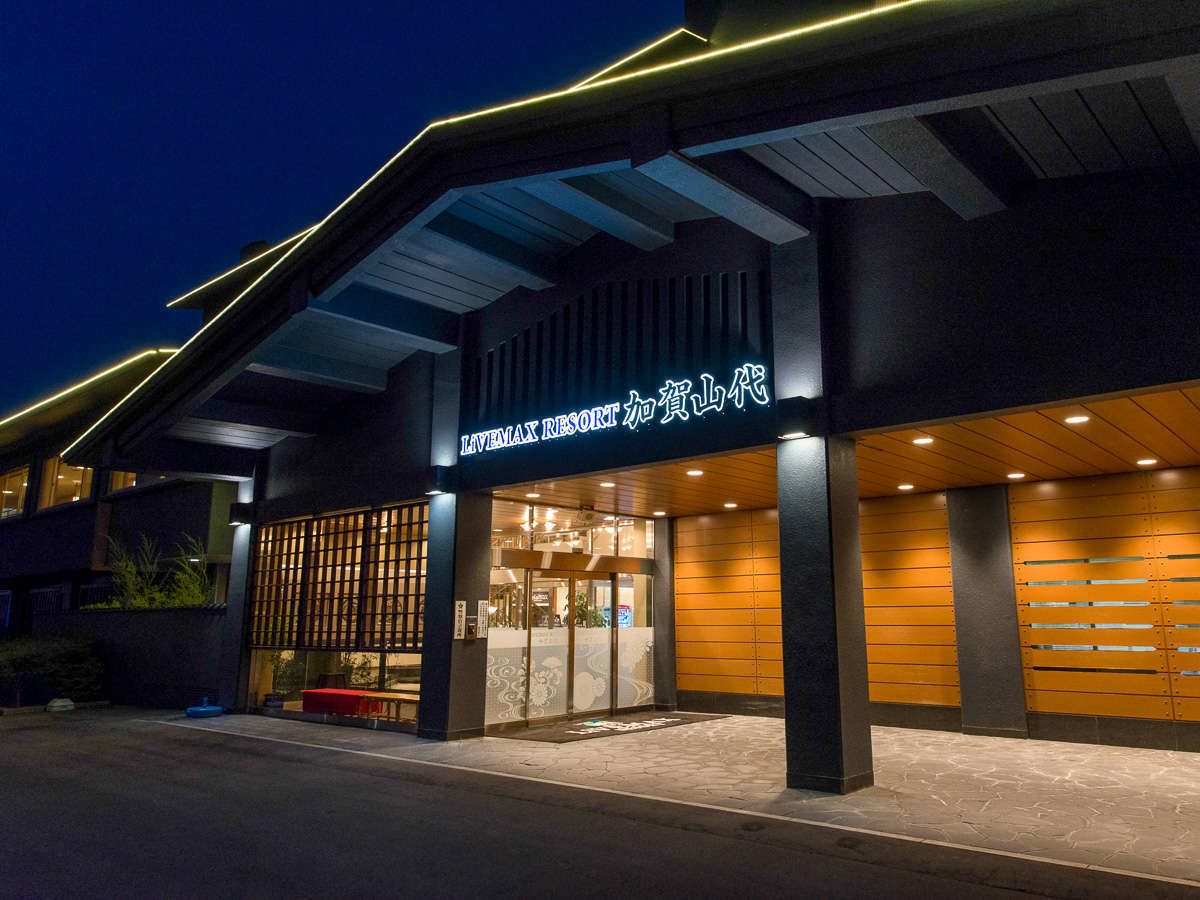 The exterior of Lavemax Resort with a modern design, featuring a prominent entrance and a well-lit facade.