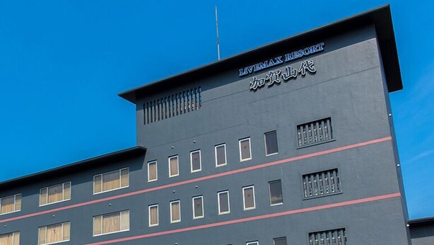 Ein mehrstöckiges Gebäude mit der Aufschrift "LIVEMAX RESORT" und "加贾山代" auf der Fassade.