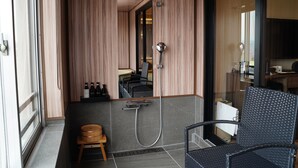 Ein modernes Badezimmer mit Dusche, einer kleinen Hocker und einem Stuhl.