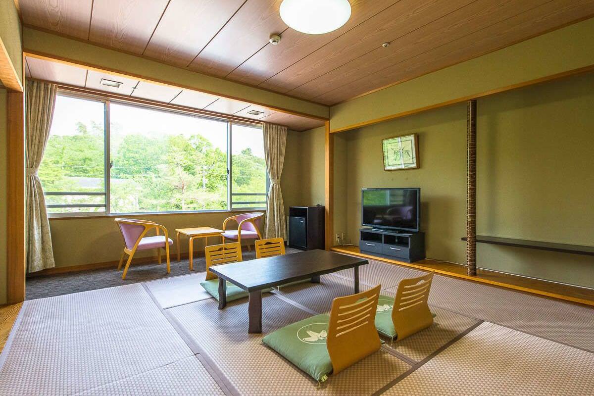 A traditional Japanese-style room with tatami mats, a low table, and chairs.
