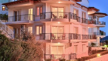 A multi-story building with balconies, staircases, and outdoor seating areas.