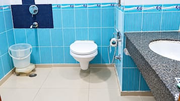 A bathroom with a toilet, a sink, and a shower.