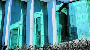A modern building with large glass windows and a white facade. - Hotel Devi Grand (Reasi)