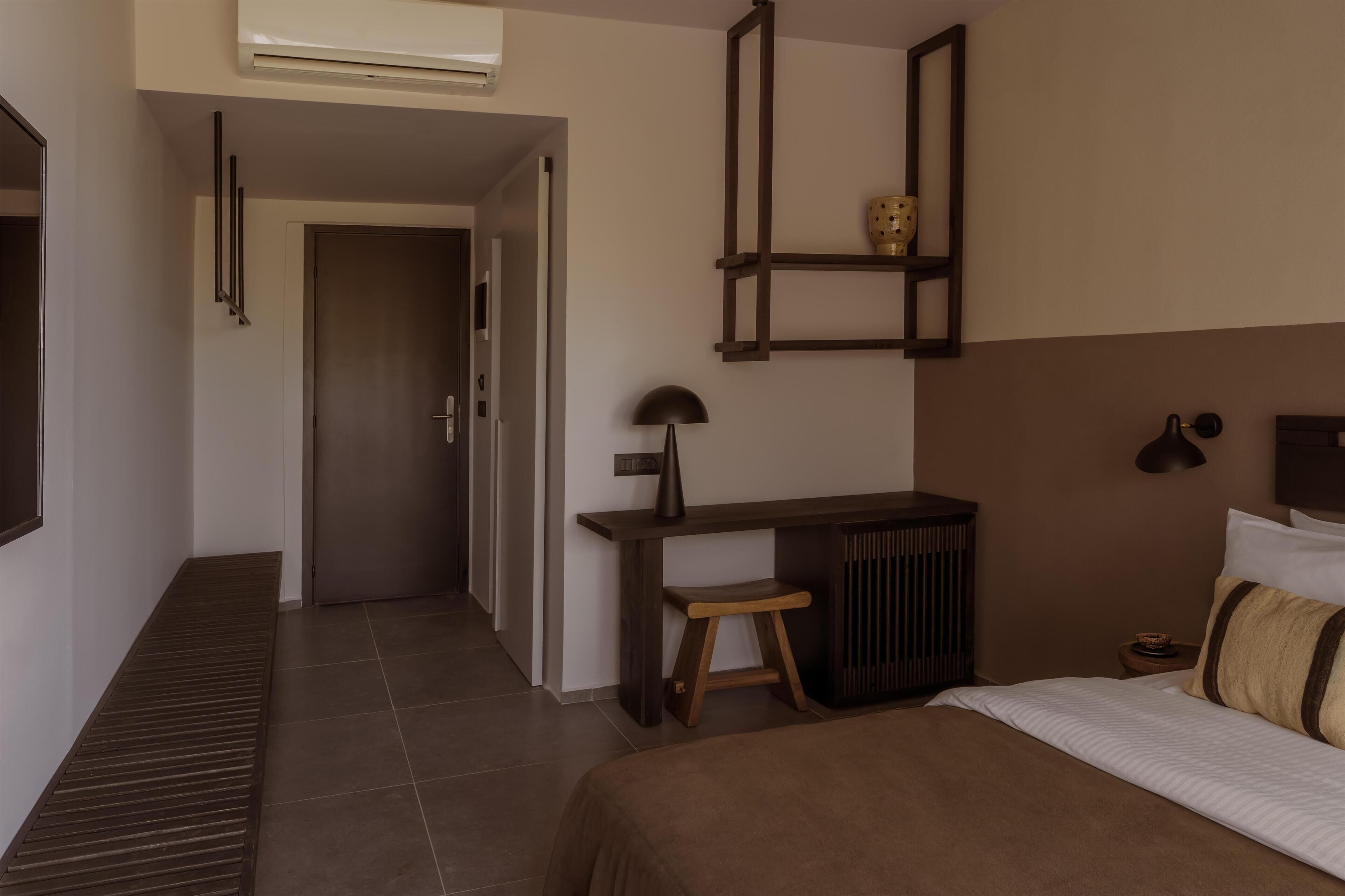 Une chambre à coucher comprenant un lit, un bureau, une chaise, un radiateur et une étagère ornée d’un objet décoratif.