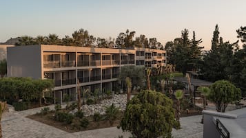 A modern hotel with multiple balconies, landscaped gardens, and a clear view of the surrounding area.