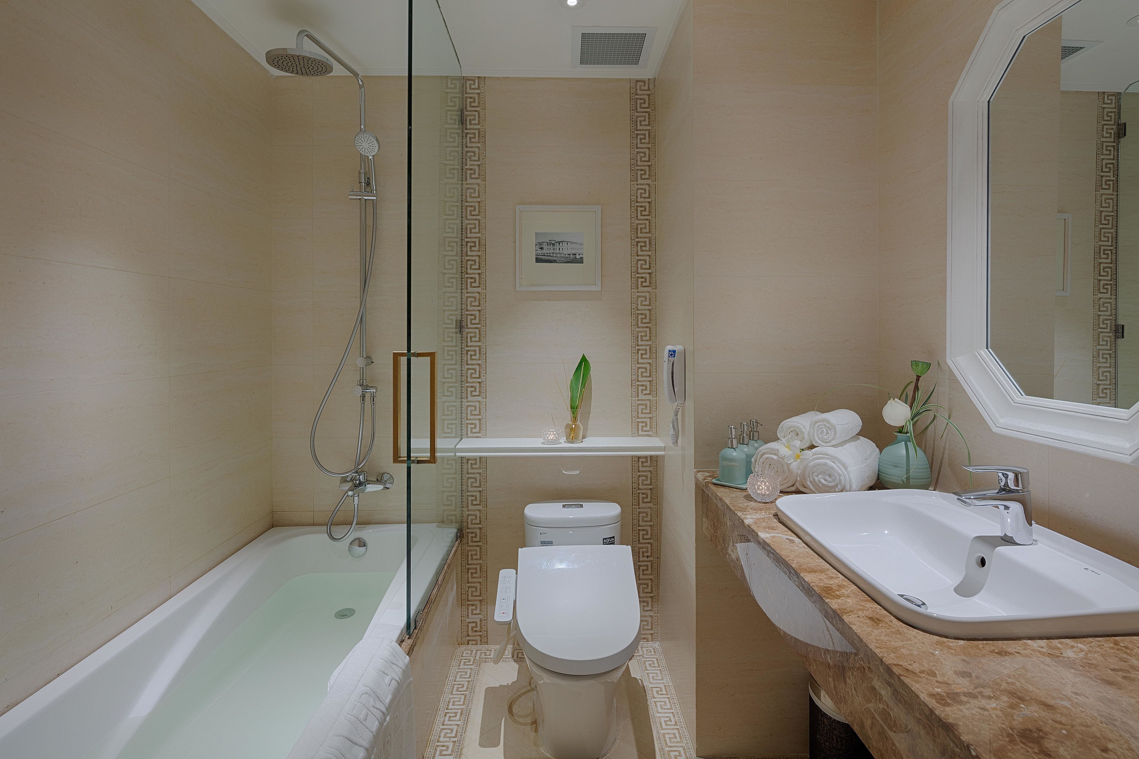 A bathroom with a bathtub, toilet, and sink.
