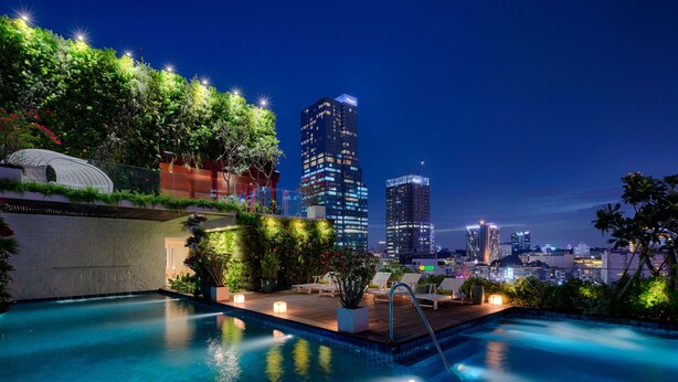 A rooftop pool with a cityscape view, including high-rise buildings and lush greenery. - Au Lac Charner Hotel (Ho Chi Minh City)