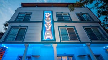 A building with a prominent neon sign spelling "POYA" on the facade.