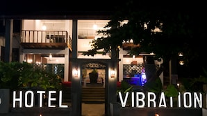 A hotel entrance with a balcony and a sign that reads "HOTEL VIBRATION". - Hotel Vibration (Hikkaduwa)