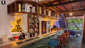 A bar area with a pool table, bar stools, and a variety of liquor bottles. - Hotel Vibration (Hikkaduwa)