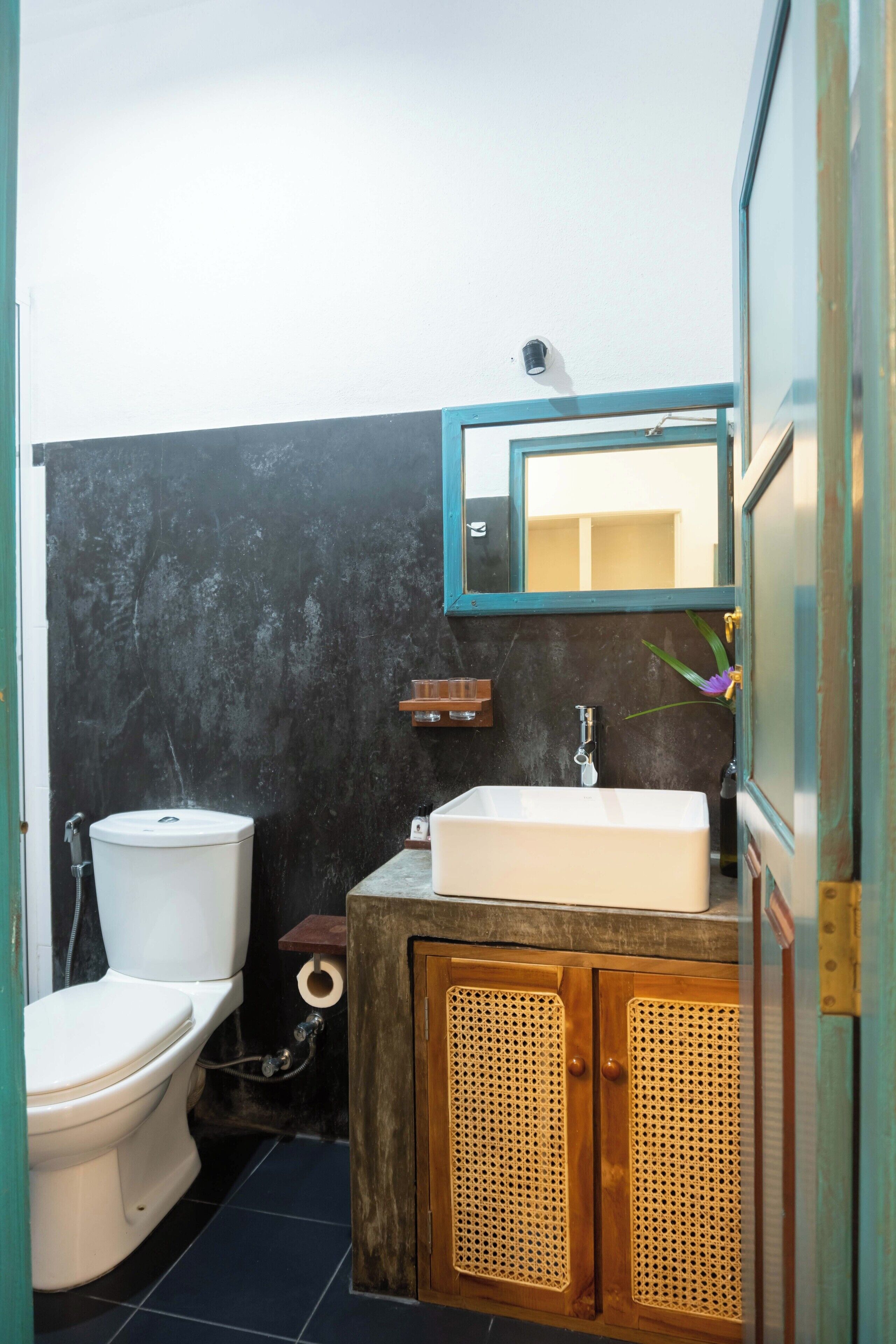 A bathroom with a toilet, sink, and wooden cabinets.