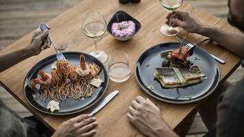 Una mesa de madera con dos platos de comida, un tenedor y un cuchillo.
